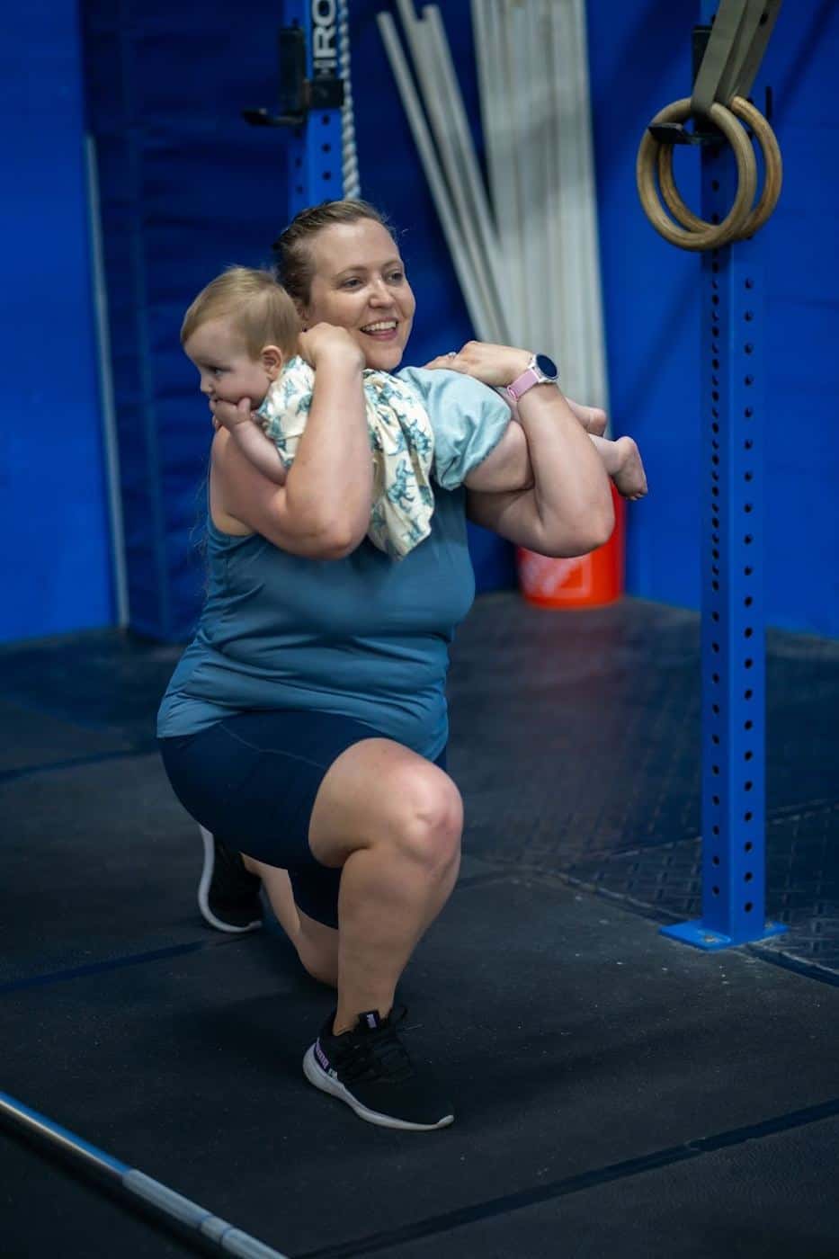 A mom squatting while holding her baby